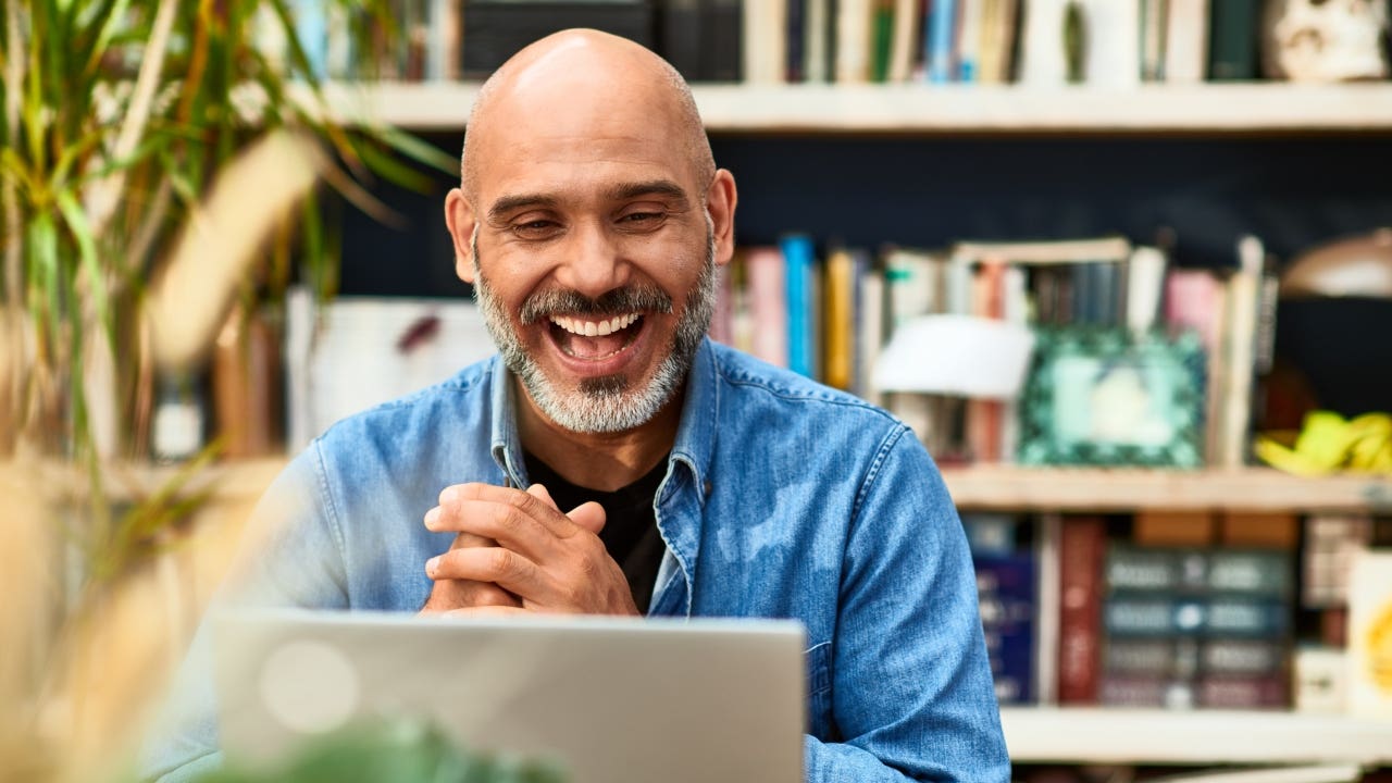 happy man using computer and clapping his hands