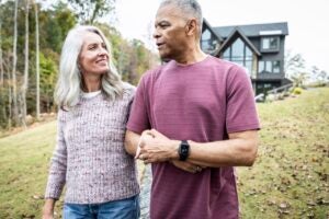 Older couple walking in front of their home