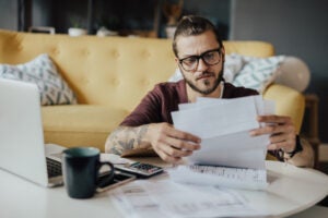 A man looks frustrated while reviewing expenses