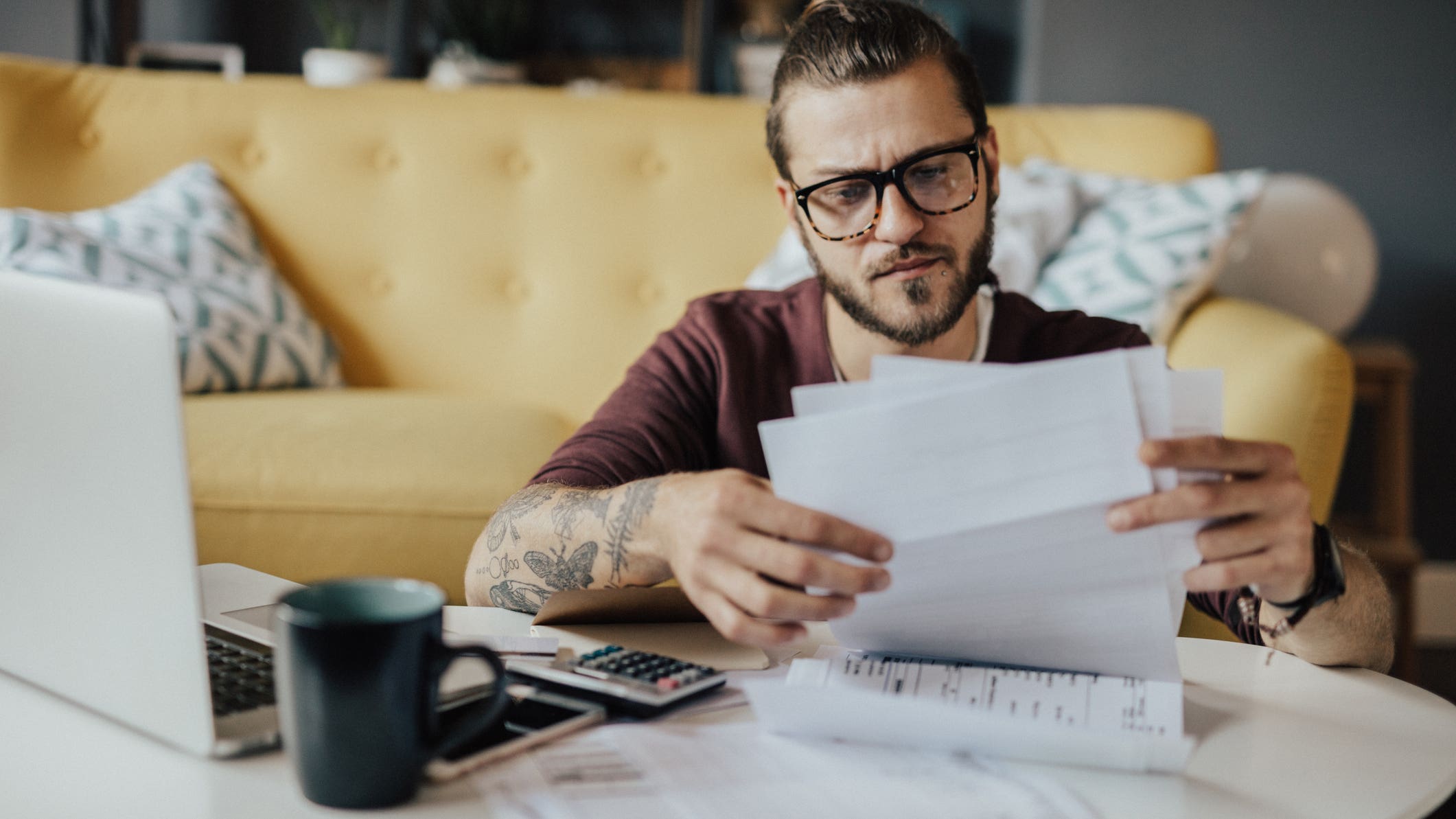 A man looks frustrated while reviewing expenses