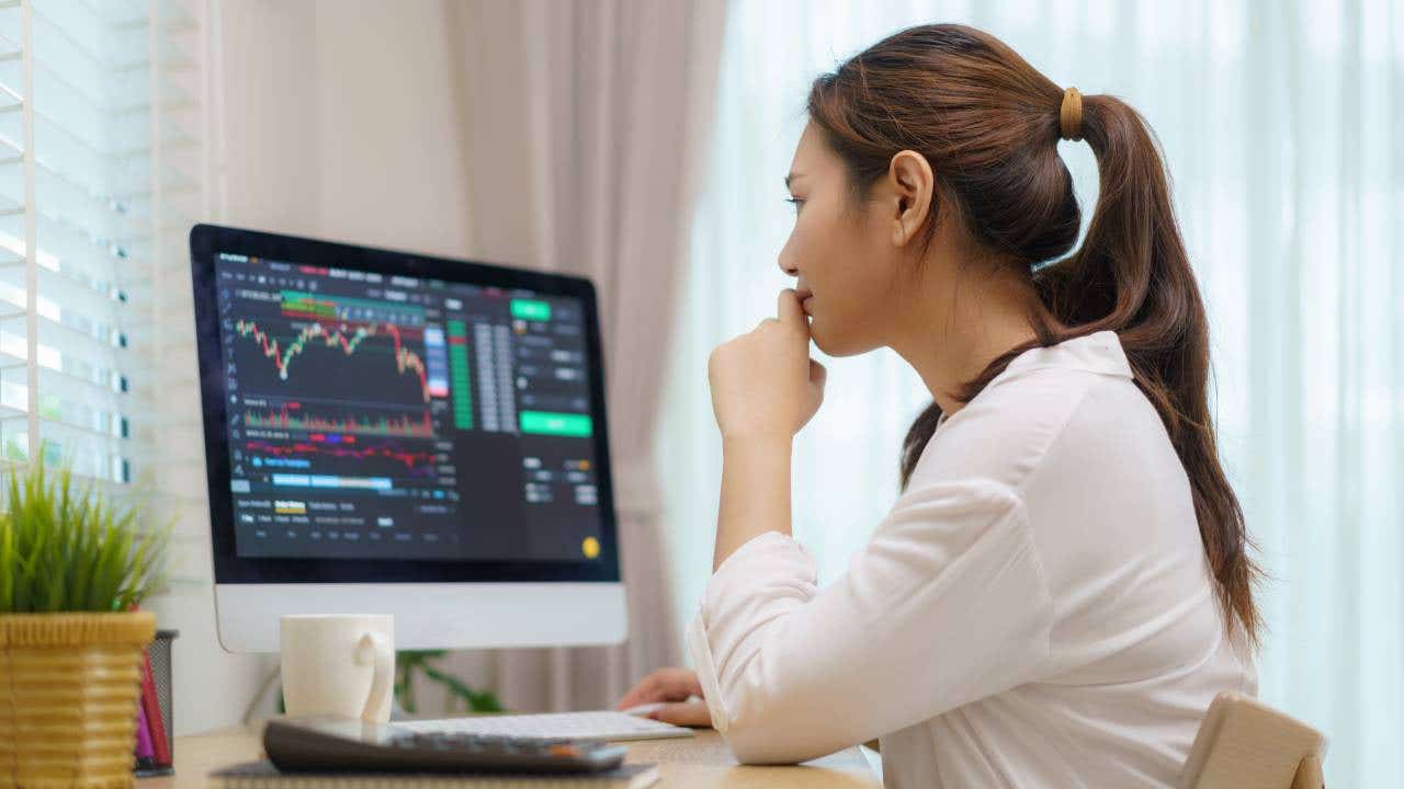 Person looking at computer monitor displaying stock data.