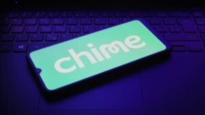 Smartphone displaying Chime logo on top of a laptop keyboard.