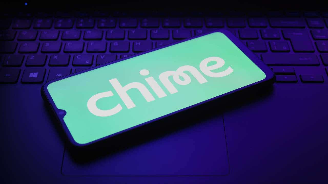 Smartphone displaying Chime logo on top of a laptop keyboard.