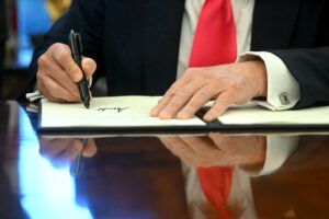 Close up of hands as Donald Trump signs executive order.