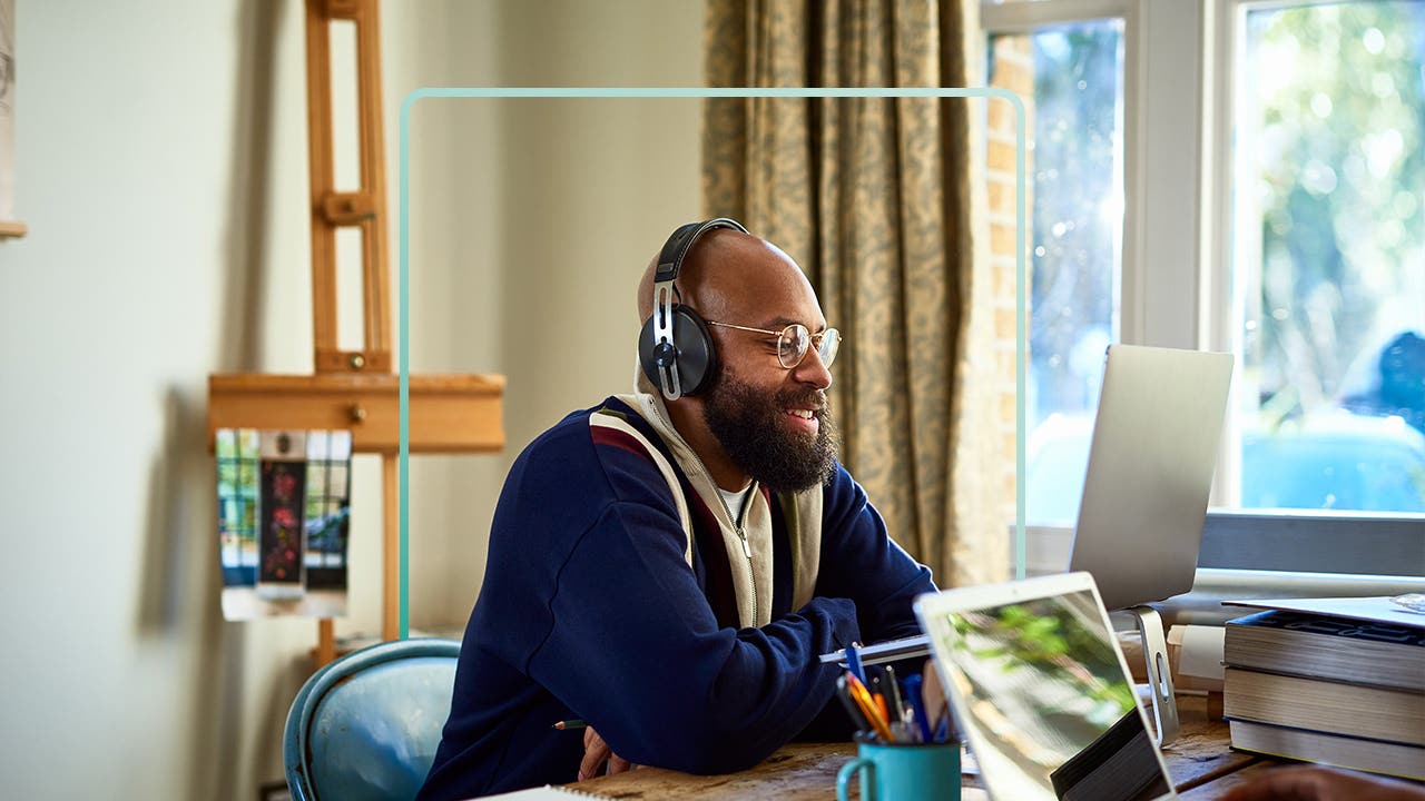 An older Black man studies on a laptop.