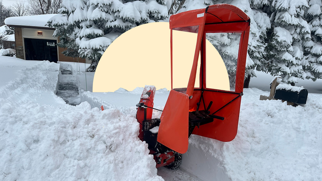 snow blower in snowy front yard