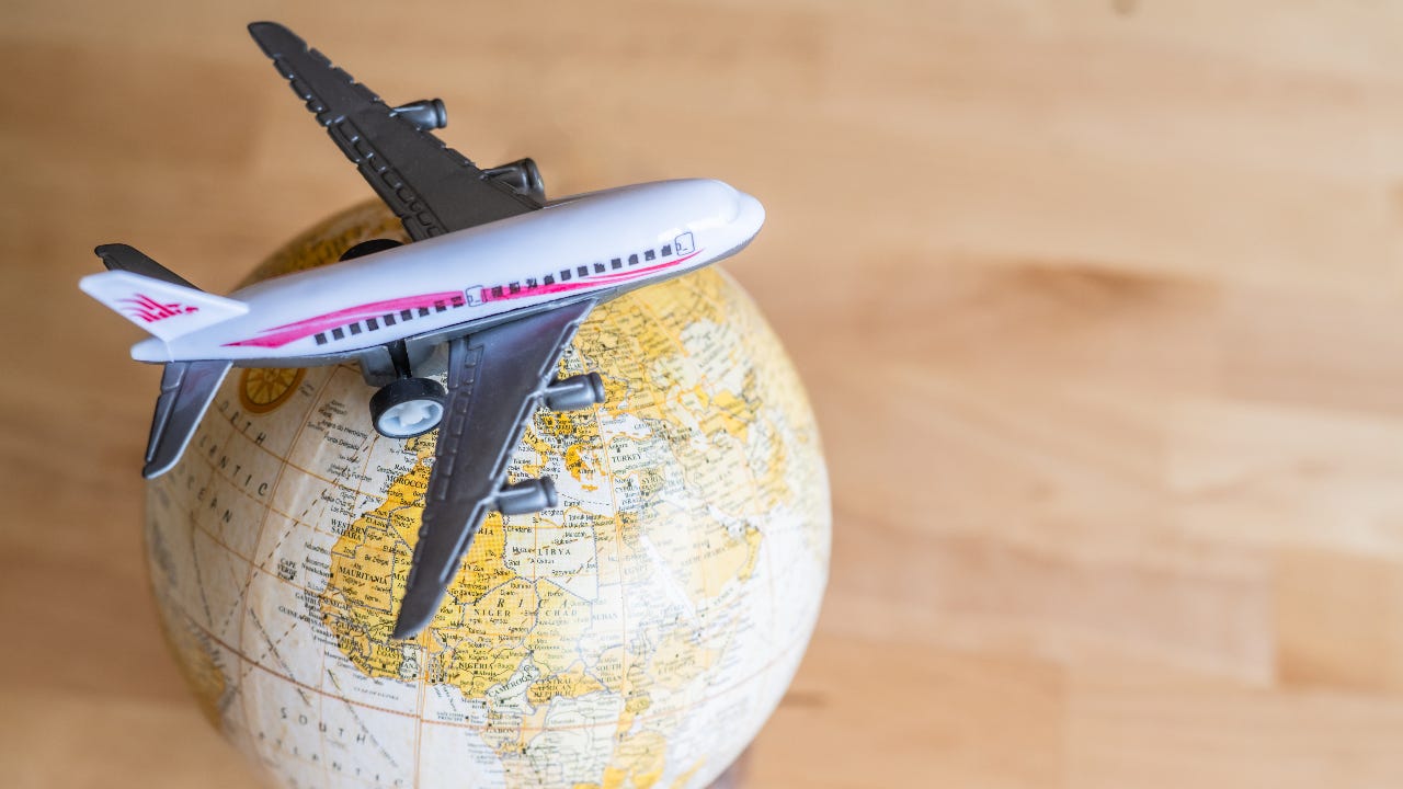 A miniature airplane sitting on a vintage globe