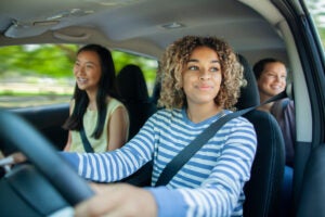 teenage girl driving with her teenage friends as passengers