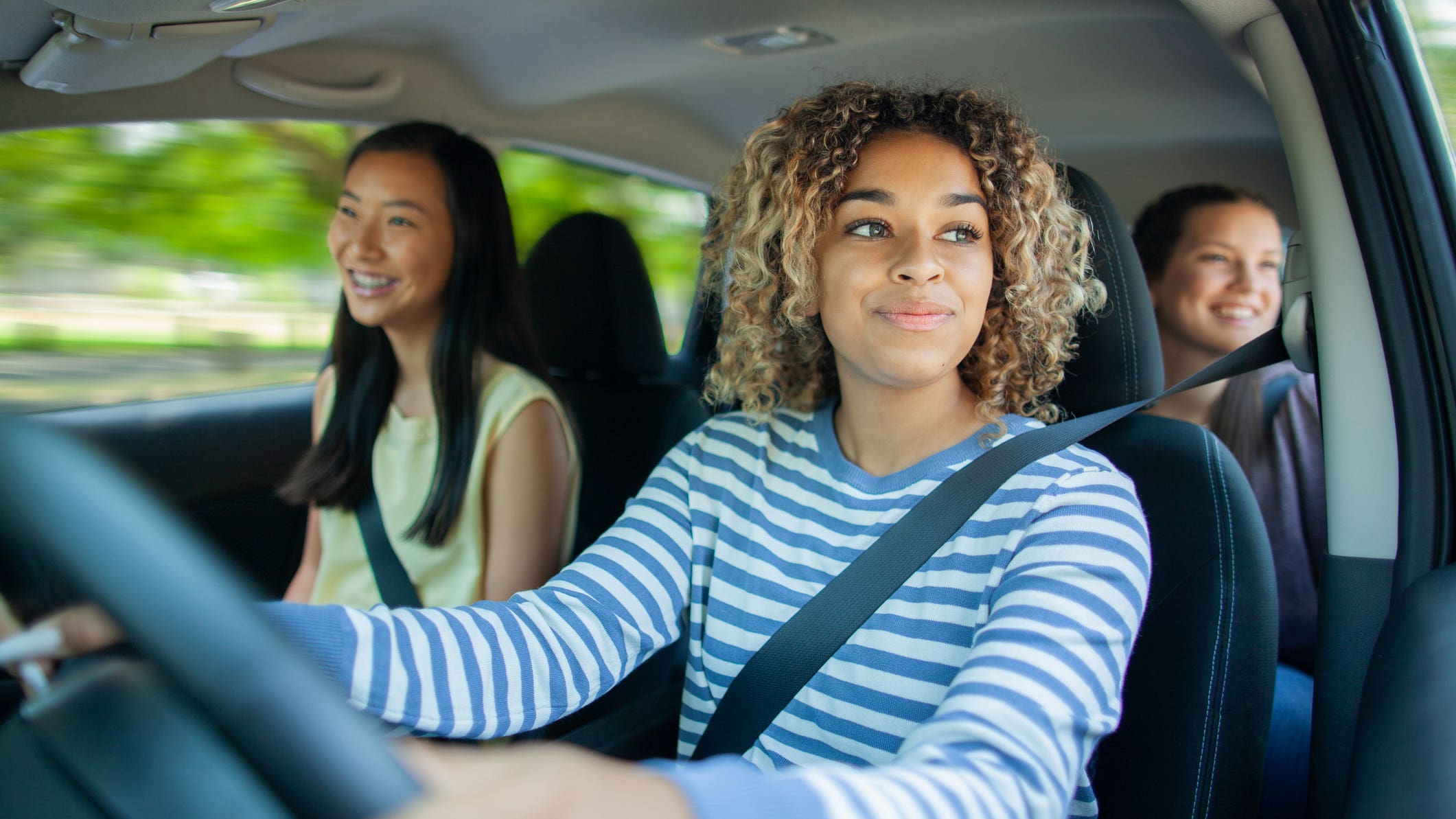 teenage girl driving with her teenage friends as passengers