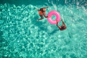 Overhead picture of two people with a innertube in a pool