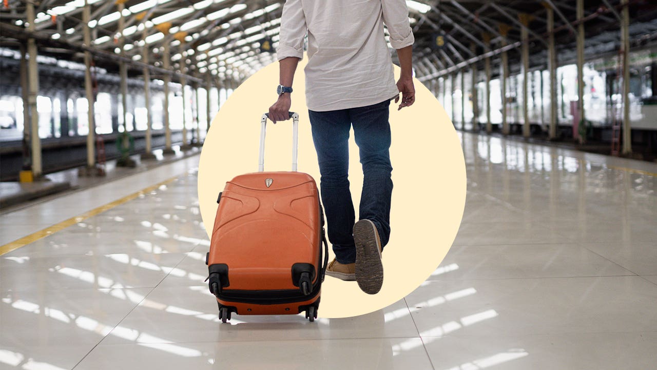 Man pulls a suitcase through an airport