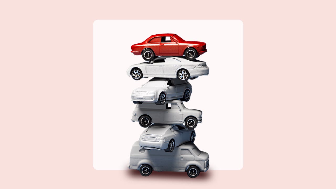 stack of cars on pink background