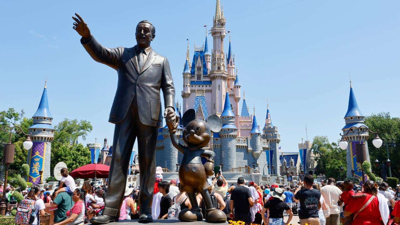 A statue of Walt Disney and Mickey Mouse stands in a garden in front of Cinderella's Castle at the Magic Kingdom Park at Walt Disney World on May 31, 2024, in Orlando, Florida.